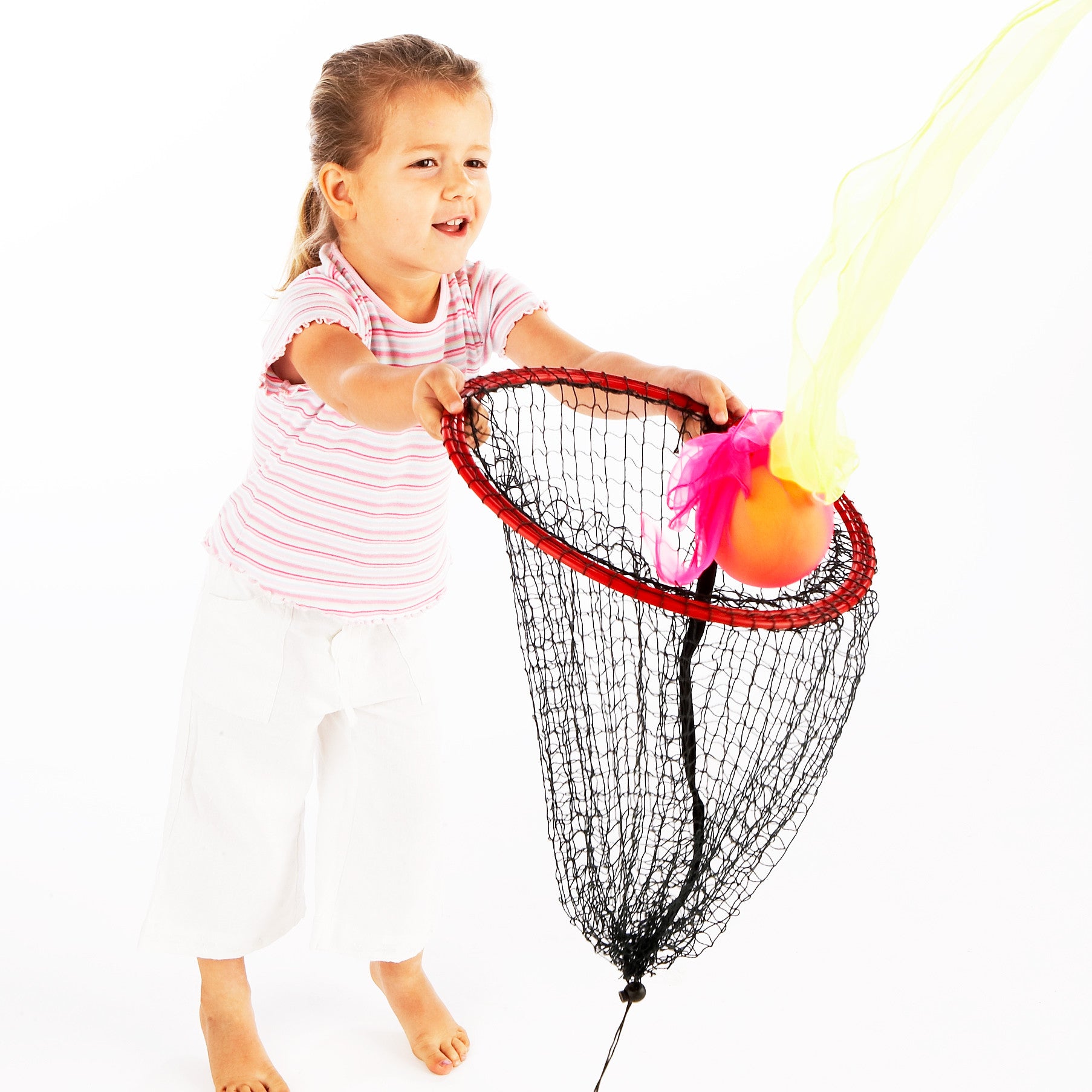 Nina catches a sponge ball, slowed down by tying Juggle Squares around it, in an Easy Catch Net.